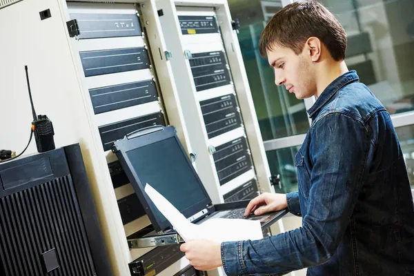Technicien procédant aux relevés dans une salle informatique
